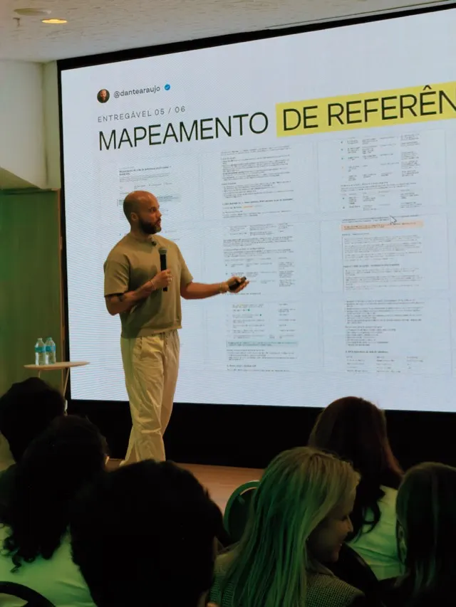 Dante Araújo palestrando sobre IA num telão com o handle @dantearaujo